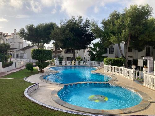 a large swimming pool in the middle of a yard at M&M Relax apartman in Torrevieja