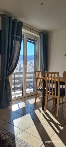 a dining room with a table and chairs and a window at Heart of Polen appartements in Piechowice