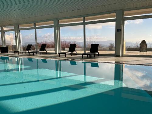 a swimming pool with chairs in a building at Ferienwohnung Uns Uwe in Freyung