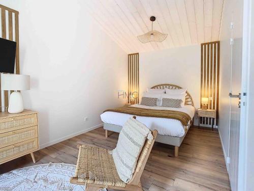 a bedroom with a bed and a chair in it at La Tranquillité in LʼHerbaudière
