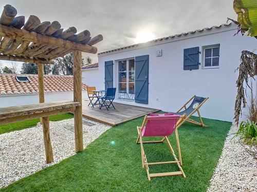 a yard with a deck and a chair and a house at La Tranquillité in LʼHerbaudière