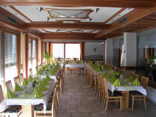 a dining room with tables and chairs with green napkins at Gasthof Zum Schwanen in Kleinostheim