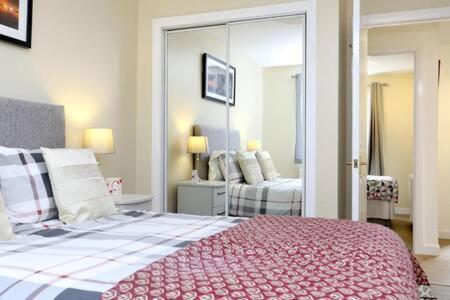 1 dormitorio con 1 cama grande y espejo en Edinburgh Apartment near University of Edinburgh - Elforma, en Edimburgo