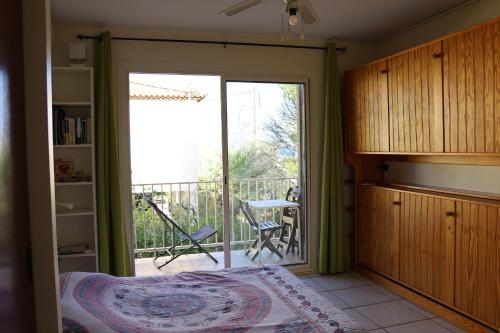 a bedroom with a sliding glass door leading to a balcony at Appart Hyères-Presqu'île de Giens-La Capte in Hyères