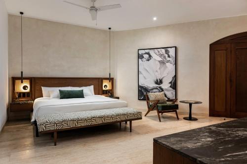 a bedroom with a bed and a chair in it at Casa Continental Hotel Boutique & Suites - Adults Only in Mérida