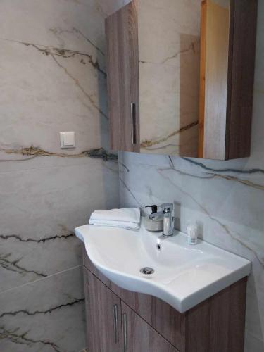 a bathroom with a white sink and a mirror at Galazio Seaside Luxury Rooms & Coffee Shop in Platamonas