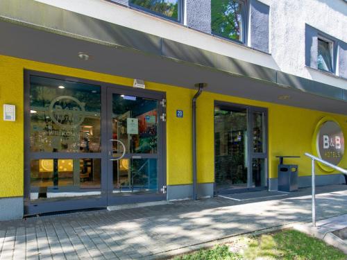 a store front with yellow walls and glass doors at B&B Hotel Passau in Passau