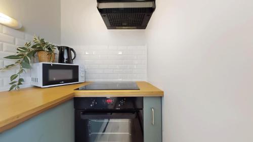 a small kitchen with a stove and a microwave at Appartement pro uniquement pas touristes ou familles in Stains