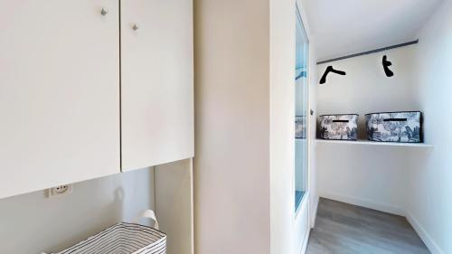 a hallway with white walls and a staircase with a glass door at Appartement pro uniquement pas touristes ou familles in Stains