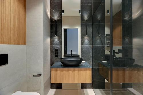 un baño con lavabo de tazón negro en una encimera en Zajezdnia Wrzeszcz 2 by Grand Apartments en Gdansk