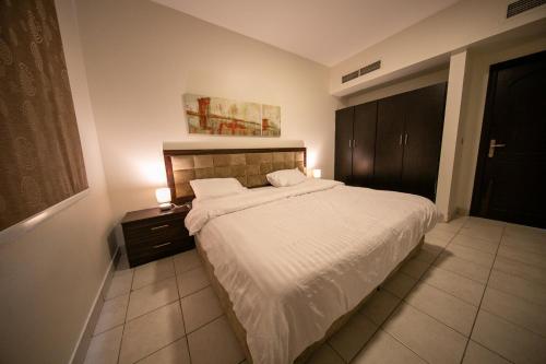a bedroom with a bed and a nightstand with a white blanket at Blue Star Villa in Durat Alarous