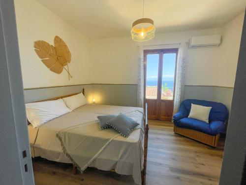 タオルミーナにあるTaormina Holiday Apartmentのベッドルーム1室(ベッド1台、椅子、窓付)