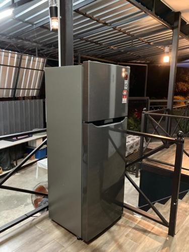 un réfrigérateur en acier inoxydable installé dans un entrepôt dans l'établissement Rods Homestay - Kg Agong Penaga, à Kepala Batas