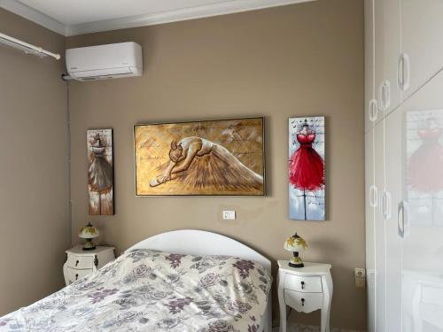 een slaapkamer met een bed en wat foto's aan de muur bij Seaview Apartments Alkis in Sarandë
