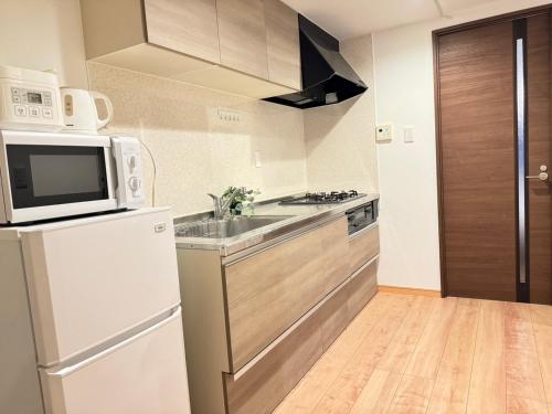東京にあるwaseda houseの白い冷蔵庫と電子レンジのあるキッチン