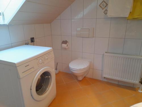 a bathroom with a washing machine and a toilet at Haus Roßner in Nemmersdorf