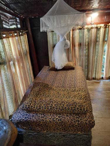 a bed with a canopy in a room with curtains at Room 2 in Ban Tham