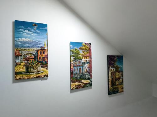 un grupo de cuatro pinturas colgando de una pared en HOTEL NILA, en Cajamarca