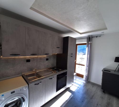 a kitchen with a stove and a washing machine at Centro Mezzano Romantica, affitto camere in Mezzano