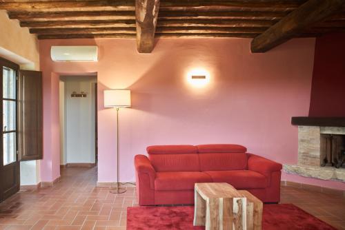 a living room with a red couch and a fireplace at Podere Sant'Antonio in Asciano