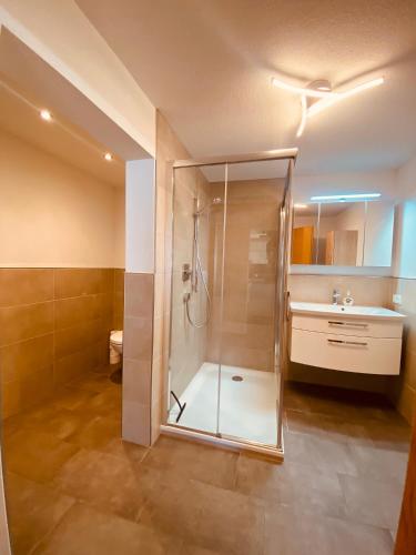 y baño con ducha y lavamanos. en Appartement am Moosbach, Fieberbrunn - St. Jakob, en Sankt Jakob in Haus