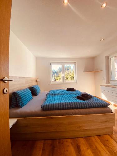 1 dormitorio con 1 cama grande con almohadas azules en Appartement am Moosbach, Fieberbrunn - St. Jakob, en Sankt Jakob in Haus