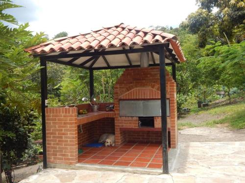 um forno de tijolos com um cão deitado sob um telhado em Casa campestre clima caliente - agroturismo em Bogotá