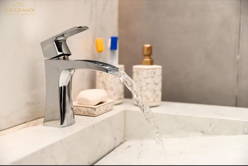 un lavabo de salle de bain avec de l'eau sortant d'un robinet dans l'établissement Deluxe Luxury Apartment, à Rawalpindi