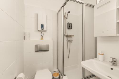 a bathroom with a shower and a toilet and a sink at FREE LIVING - City Design Apartments, Zentrum, Outlet, Balkon, Küche in Wolfsburg