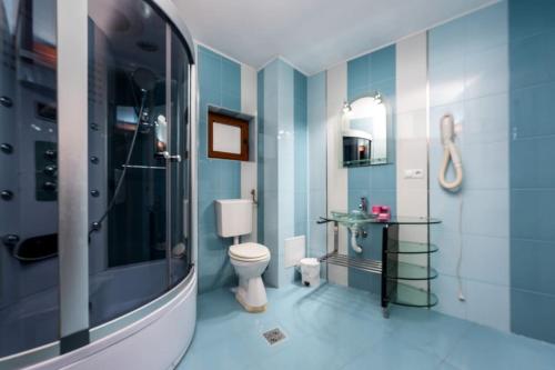 a bathroom with a toilet and a sink and a shower at Central Apartament Predeal Nr 6 in Predeal