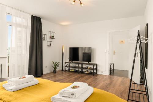 a bedroom with a yellow bed and a television at FREE LIVING - City Design Apartments, Zentrum, Outlet, Balkon, Küche in Wolfsburg