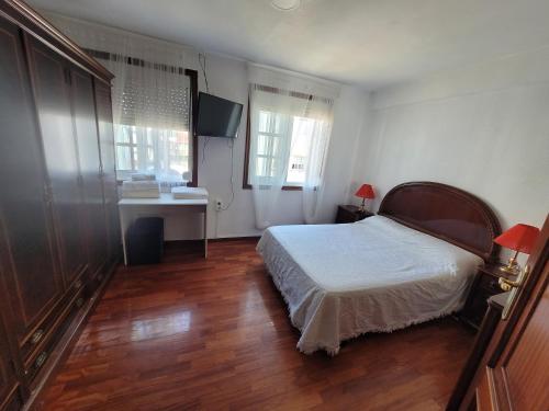 1 dormitorio con cama, escritorio y ventana en APT FAMILIAR VIGO, en Vigo