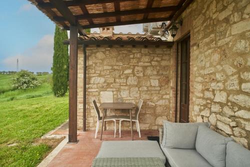 a patio with a table and chairs and a couch at Podere Sant'Antonio in Asciano
