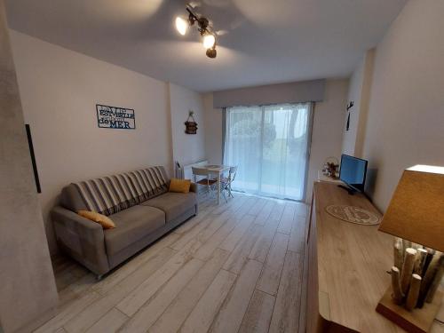 un salon avec un canapé et une table dans l'établissement Studio au calme, plage et centre à pied, jardinet ensoleillé, parking privé - FR-1-550-51, à Saint-Georges-de-Didonne
