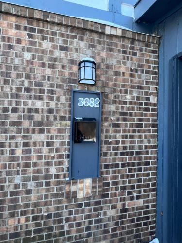 a blue door on a brick wall with a light at Blessing Home IN in Indianapolis