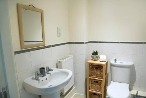 a bathroom with a sink and a toilet and a mirror at Cosy 2-Bedroom Flat in Warrington in Warrington