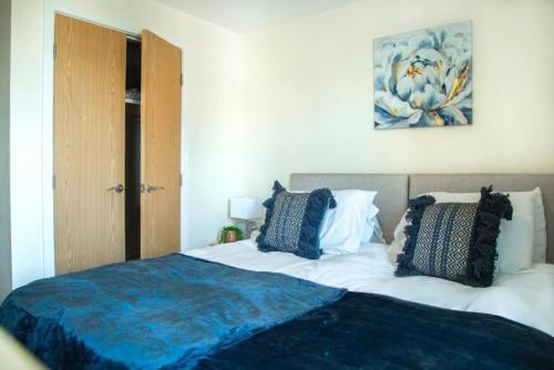 a bedroom with a bed with blue and white pillows at Cosy 2-Bedroom Flat in Warrington in Warrington