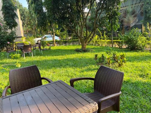a table and chairs in the grass with a table and chairs at Airportlinkguesthouse2 in Entebbe