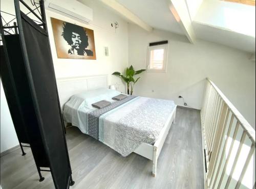 um quarto com uma cama num quarto branco em Chez Camille et David em Sorgues