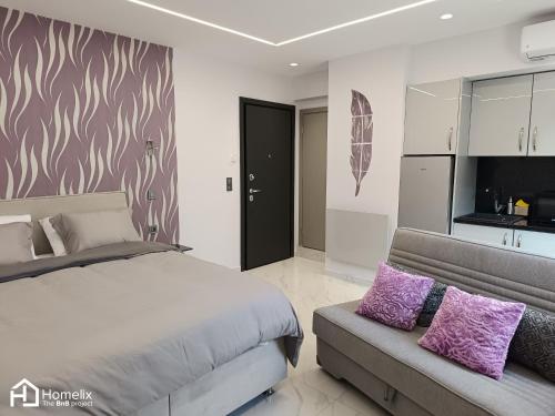 1 dormitorio con 1 cama y 1 sofá con almohadas moradas en Modern studio in the city center, en Chalkida