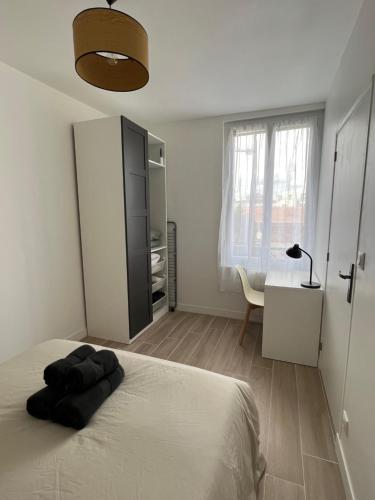 une chambre avec un lit et un bureau avec une lampe dans l'établissement Appartement contemporain et lumineux, à Aubervilliers