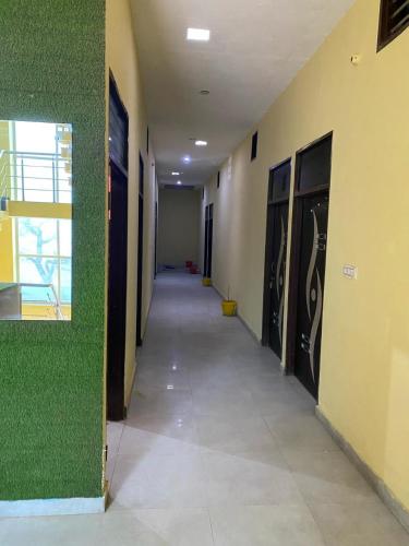 un corridoio vuoto in un edificio con pareti verdi di Hansi Hotel a Hānsi