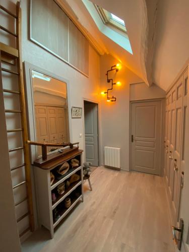 un couloir avec un miroir et une chambre avec des bouteilles de vin dans l'établissement La Patriaie. chez Jacky et Maryse., à Sainte-Maure-de-Touraine
