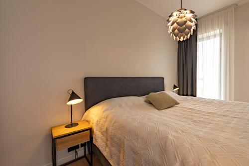 um quarto com uma cama e um lustre em Artisa Riia Str 20a Luxury Penthouse Apartment em Tartu