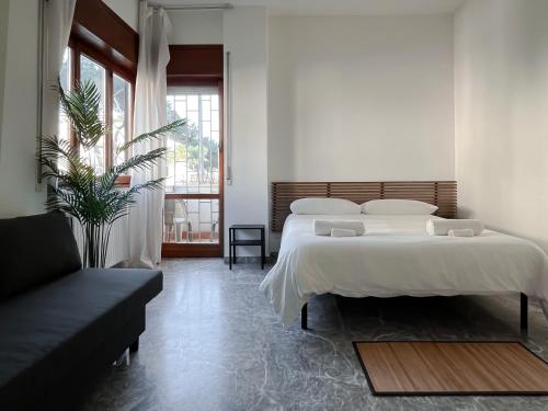 una camera con un grande letto e un divano di Pascià Rooms a Roma