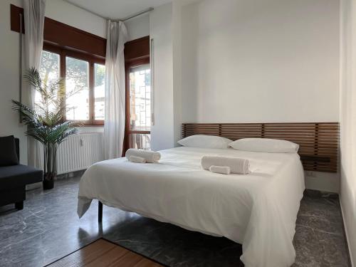 a bedroom with a large white bed with two pillows at Pascià Rooms in Rome