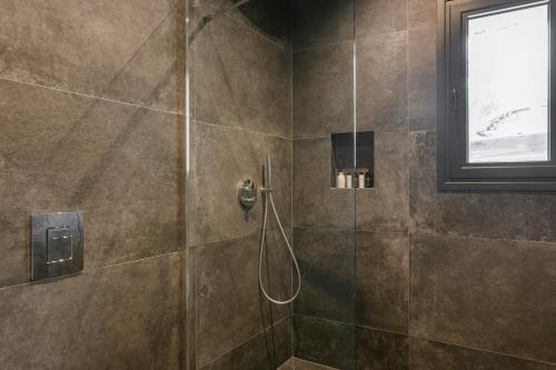 a bathroom with a shower with a glass door at Petra Tranquila Villa in Kefallonia