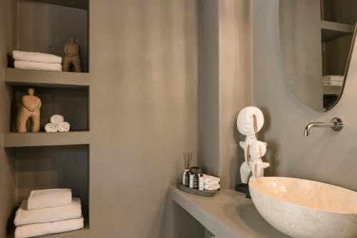 a bathroom with a sink and a mirror and towels at Petra Tranquila Villa in Kefallonia