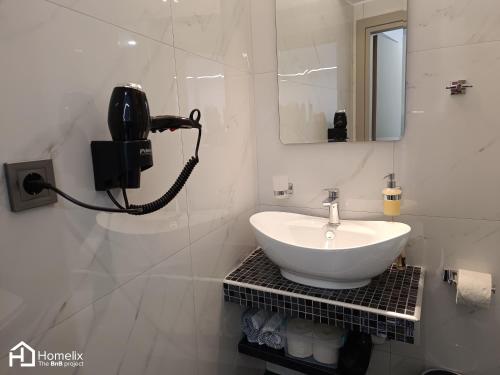 łazienka z umywalką i telefonem na ścianie w obiekcie Modern studio in the city center w Chalkidzie