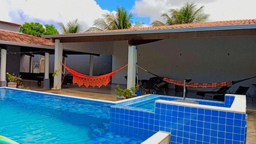 a villa with a swimming pool and a house at Casa Maravilhosa em Caravelas Ba in Caravellas